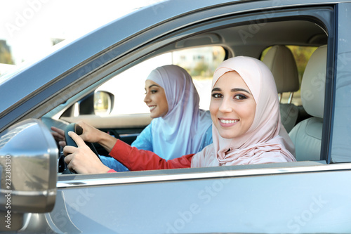 Female Muslim driver and her friend in car