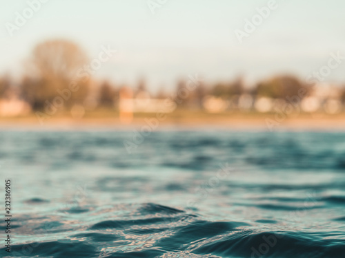 small waves on the Rhine river with opposite shore blurry in background