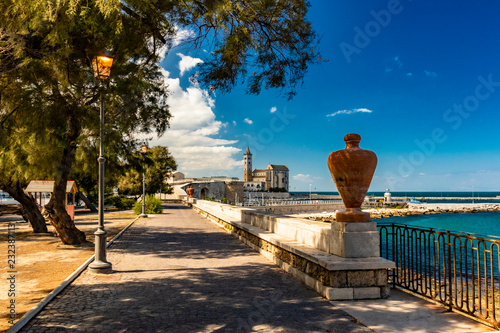 The beautiful Romanesque Cathedral Basilica of San Nicola Pellegrino, in Trani. Construction in limestone tuff stone, pink and white. A pointed arch under the bell tower. In Puglia, Bari, Barletta