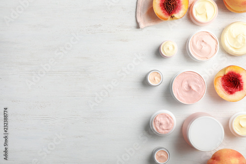 Flat lay composition with hand cream jars and space for text on wooden background