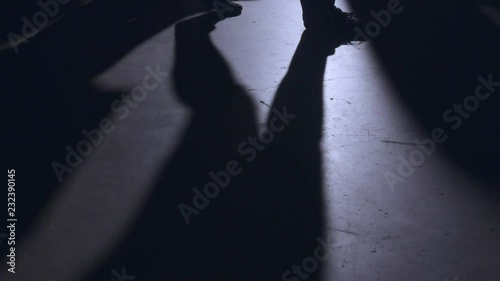 Shadows of people walking across a concrete floor.