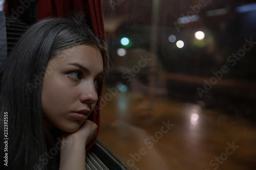 Thinking woman looking out of the train window at night