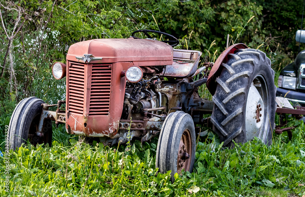 Full shot of a vintage red tractor on a sunny day.