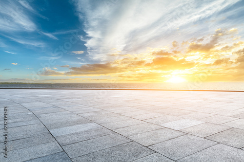 Empty square floor and dramatic sky with coastline at sunset © ABCDstock