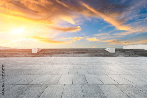 Empty square floor and dramatic sky with coastline at sunset