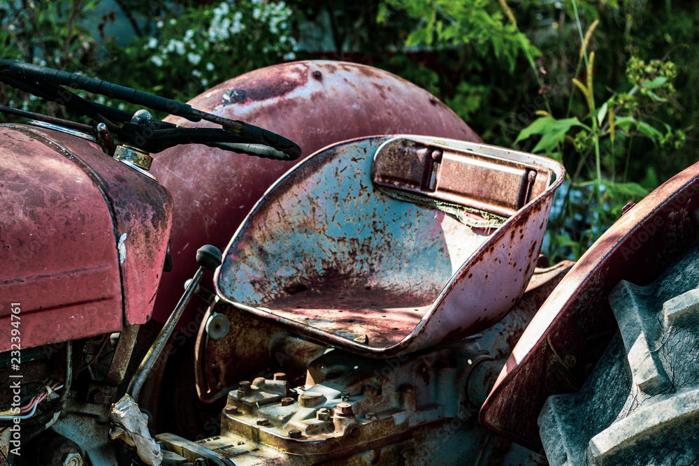 Looking at the drivers seat of a vintage tractor aged and worn from sitting in the sun.