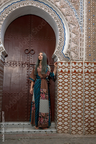 Young European woman model standing at Traditional Maroccan patern entrance door