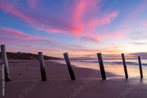 Foto A beautiful sunset at moana beach with the wooden posts seperating the beach in