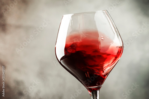 Spanish dry red wine, splash in glass, from the tempranillo grape, gray stone background, defocused in motion image, shallow depth of field