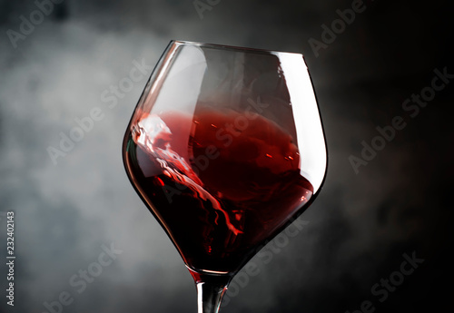 Spanish dry red wine, splash in glass, from the tempranillo grape, gray stone background, defocused in motion image, shallow depth of field