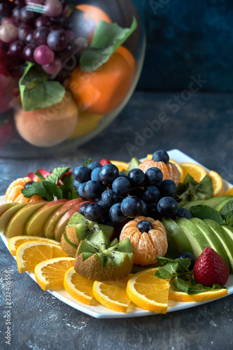 fruit plate. Glass bank of lemonade with sliced citrus fruits on a buffet table