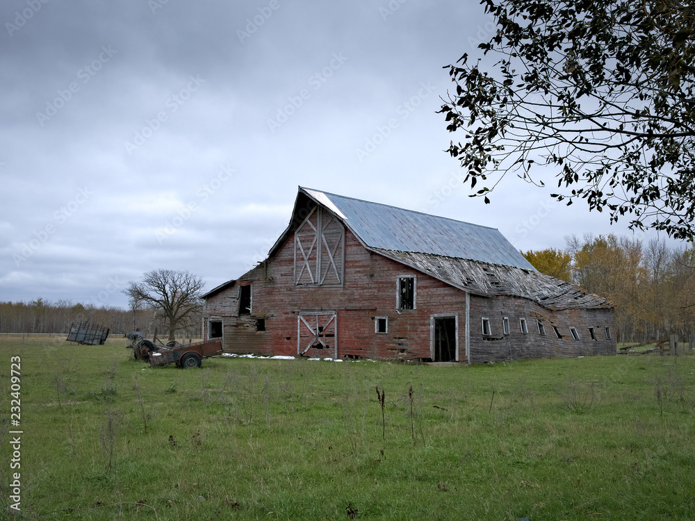 Dreary Abandoned Dilapidated Farm Barn with cloudy skies in northern Minnesota