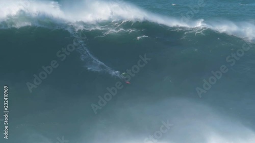 Big wave surfer Carlos Burle riding a monster wave in Nazar√©, Portugal. Nazar√© is a small village in Portugal with the biggest waves in the world. photo