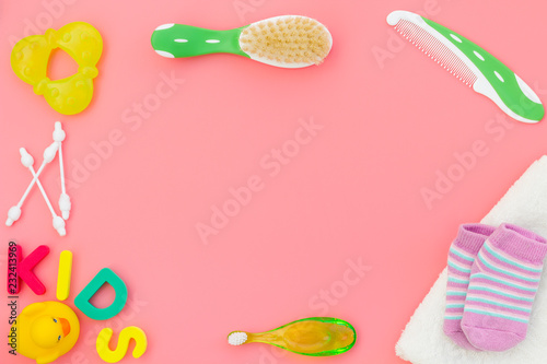 Hygiene items for the child. Bath accessories with yellow rubber duck on pink background top view copy space frame. Word KIDS