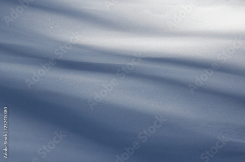Silky soft velvet abstract shape blue long shadows on the white fresh snow in