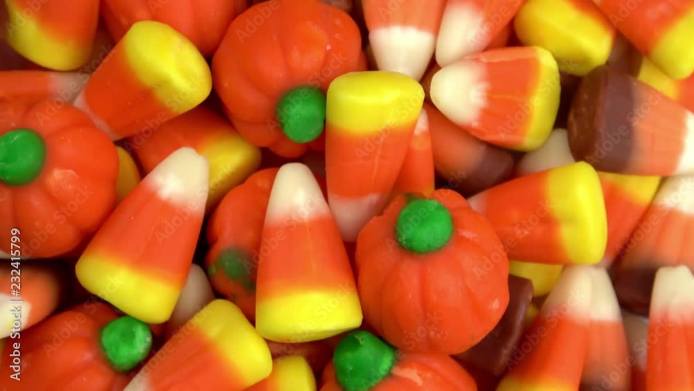 Halloween corn candies and pumpkins spinning video close up