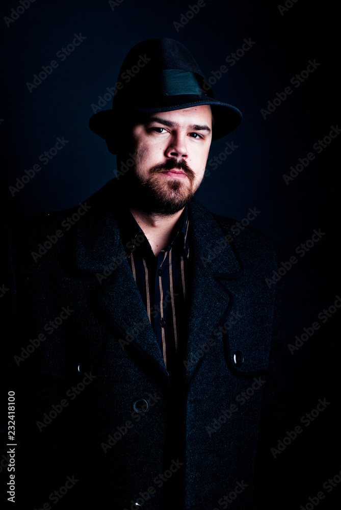 man in a black hat and coat on a dark background, Studio photo man in a black hat and coat on a dark background, Studio photo