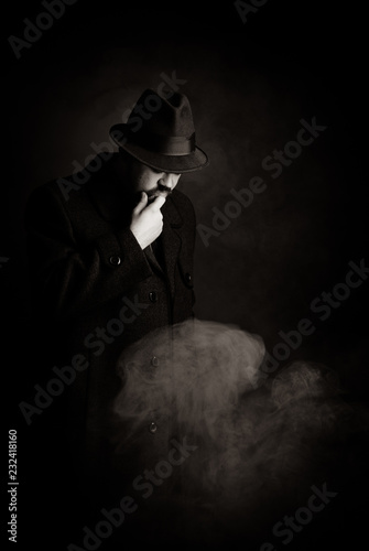 man in a black hat and coat on a dark background, Studio photo
