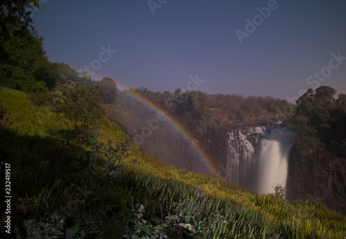 Victoria Falls,Zimbabwe-August 17, 2016: A lunar rainbow or a moonbow on the Victoria Falls observed within 2 days of full moon. Since the lunar rainbows are much fainter than the day-time ones, long-