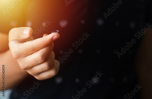 Focus on contact lens on finger of young handsome teen man young male . Close-up Of Young Man Holding Contact Lens On Finger Eyesight and eyecare concept. Ophtalmology concept versus wearing glasses