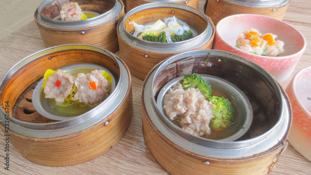 close up of set steamed dim sum dumplings in basket, chinese traditional food