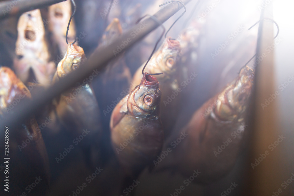 Fish smoked on hooks in smokehouse