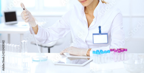 Female scientific researcher or blood test assistant at work in laboratory. Science, medicine and pharmacy concept