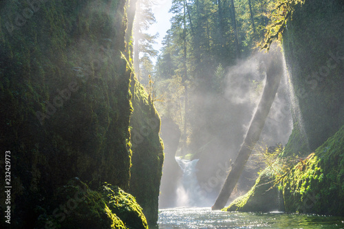 Columbia River Gorge - Hood River, Oregon. Sun shines on small waterfall and forest stream