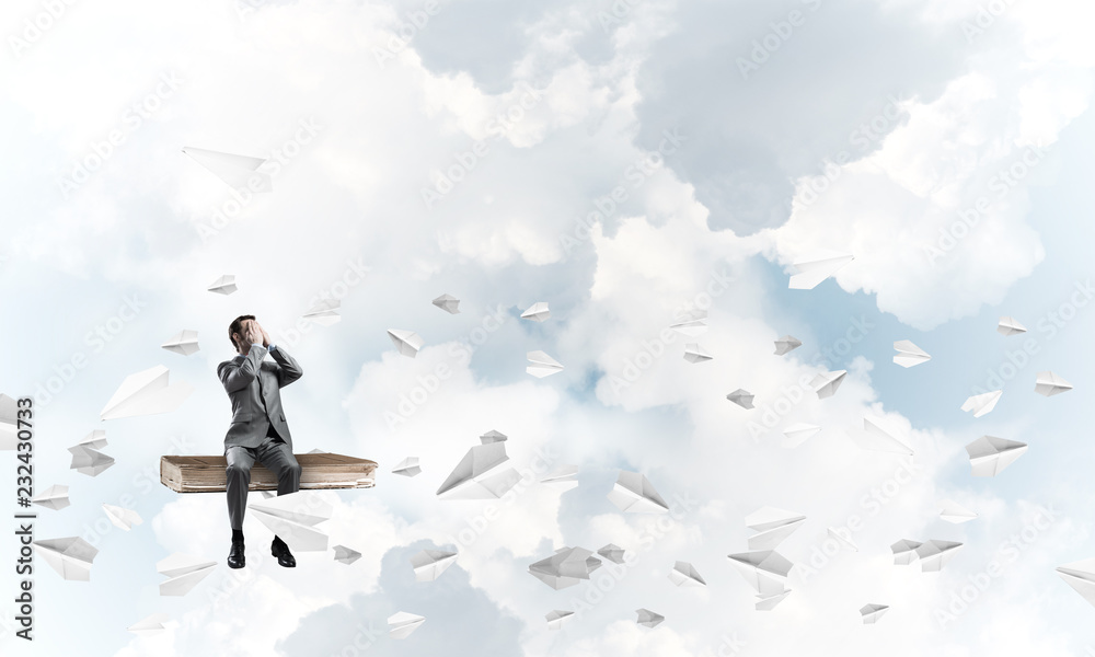 Young man do not want to see anything and paper planes fly around Young man do not want to see anything and paper planes fly around
