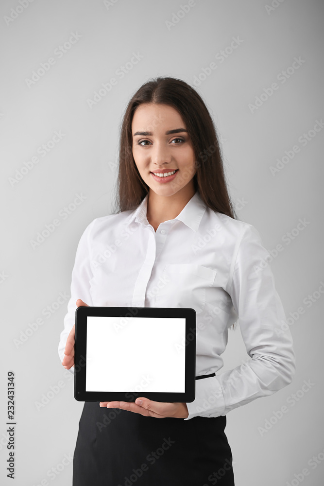Beautiful young woman with tablet computer on light background Beautiful young woman with tablet computer on light background
