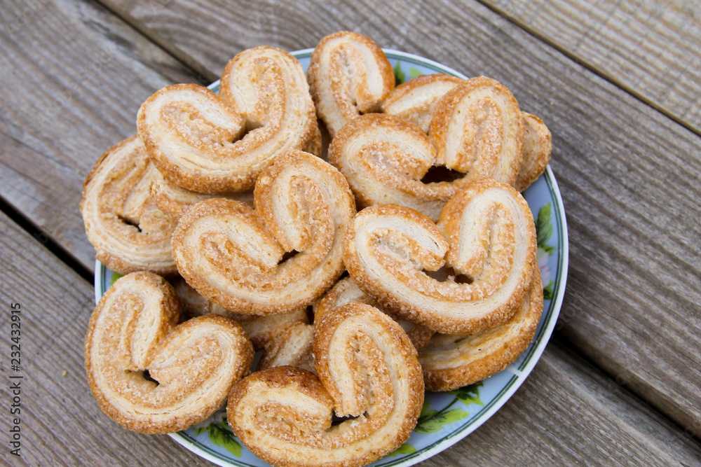 Palmier cookies in a plate on wooden table Palmier cookies in a plate on wooden table