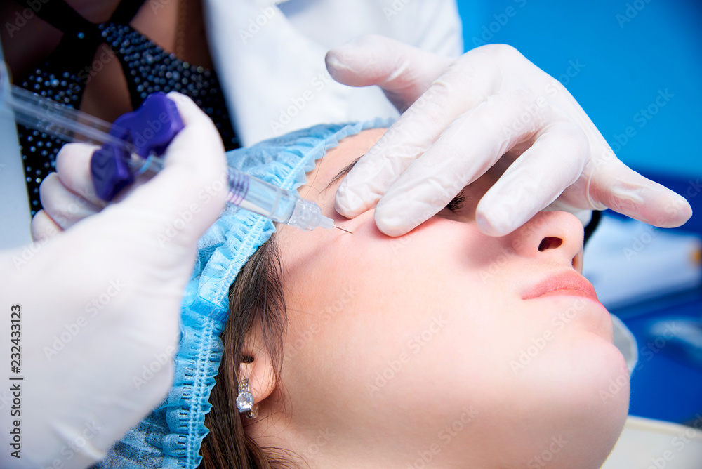 Fototapeta premium Beautiful young woman gets injection in her face.Beauty injections and cosmetology.Plastic and aesthetic surgery.
