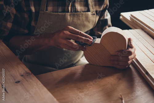 Cropped closeup photo of small tiny little heart shaped wooden d photo