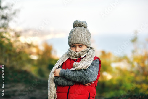 Obraz na płótnie portrait of a teenage boy on a cold autumn day . child in warm knitted hat and scarf w salonie