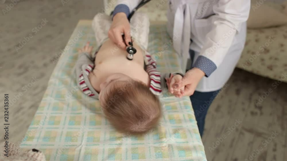 Pediatric doctor exams newborn baby boy with stethoscope in hospital. Doctor checking a baby's heartbeat with a stethoscope. Pediatric doctor exams newborn baby boy with stethoscope in hospital. Doctor checking a baby's heartbeat with a stethoscope.