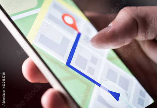 Map application in smartphone. Man navigating in city with mobile phone. Person using cellphone and searching hotel with navigation app. Macro close up of screen. photo