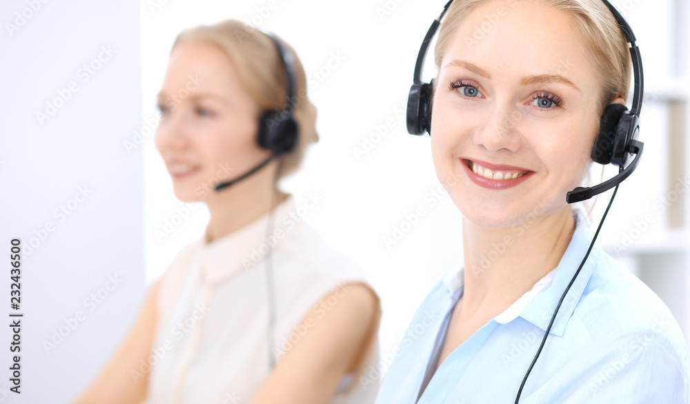 Bright call center office. Two blonde women in a headset Bright call center office. Two blonde women in a headset