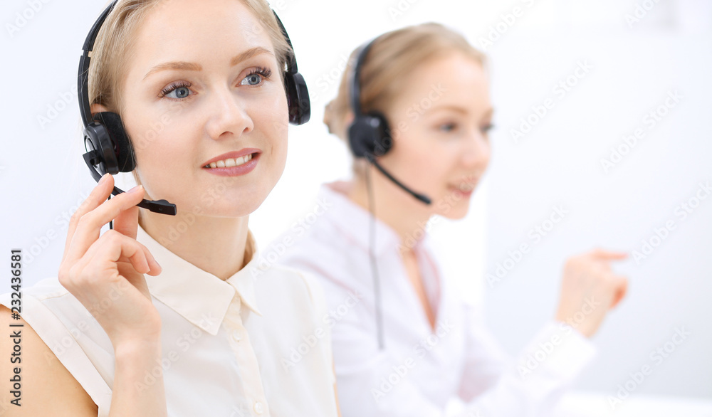 Bright call center office. Two blonde women in a headset Bright call center office. Two blonde women in a headset