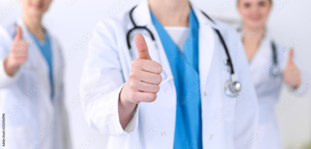 Groupe of medicine doctors show OK sign with thumb up close up. Success and high level service in health care, best treatment and customer loyalty and physical concept. Copy space for advertisement Groupe of medicine doctors show OK sign with thumb up close up. Success and high level service in health care, best treatment and customer loyalty and physical concept. Copy space for advertisement