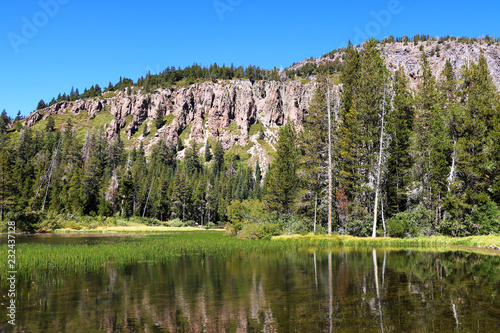 Shallow quiet blue Mammoth Lake among the mountains and pine forests