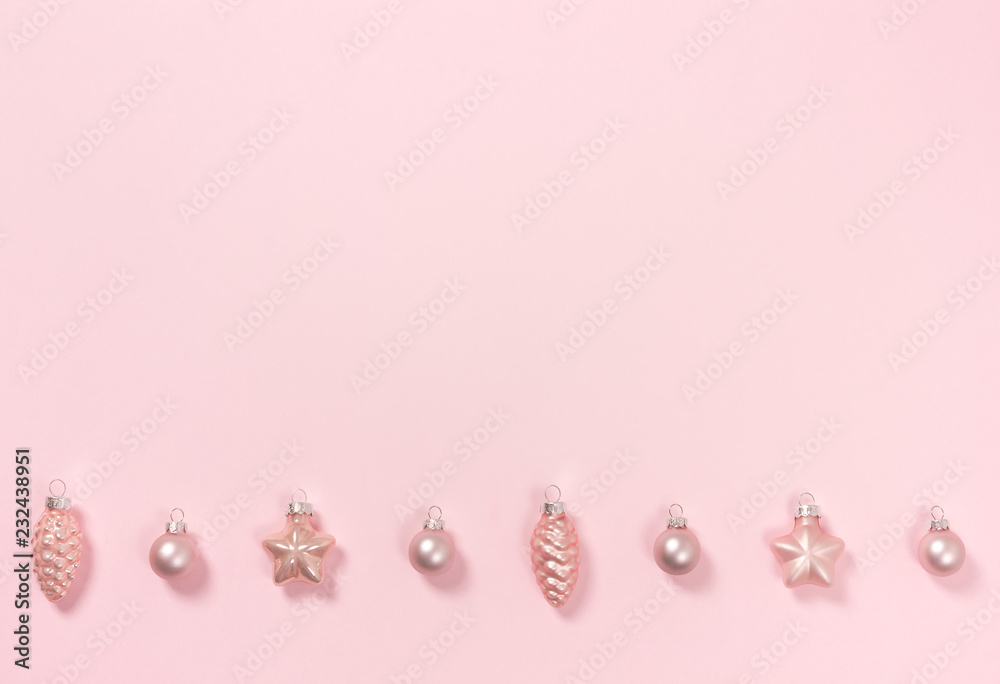 Delicate pink pastel background with a row of beautiful pink baubles. Top view. Place for text.