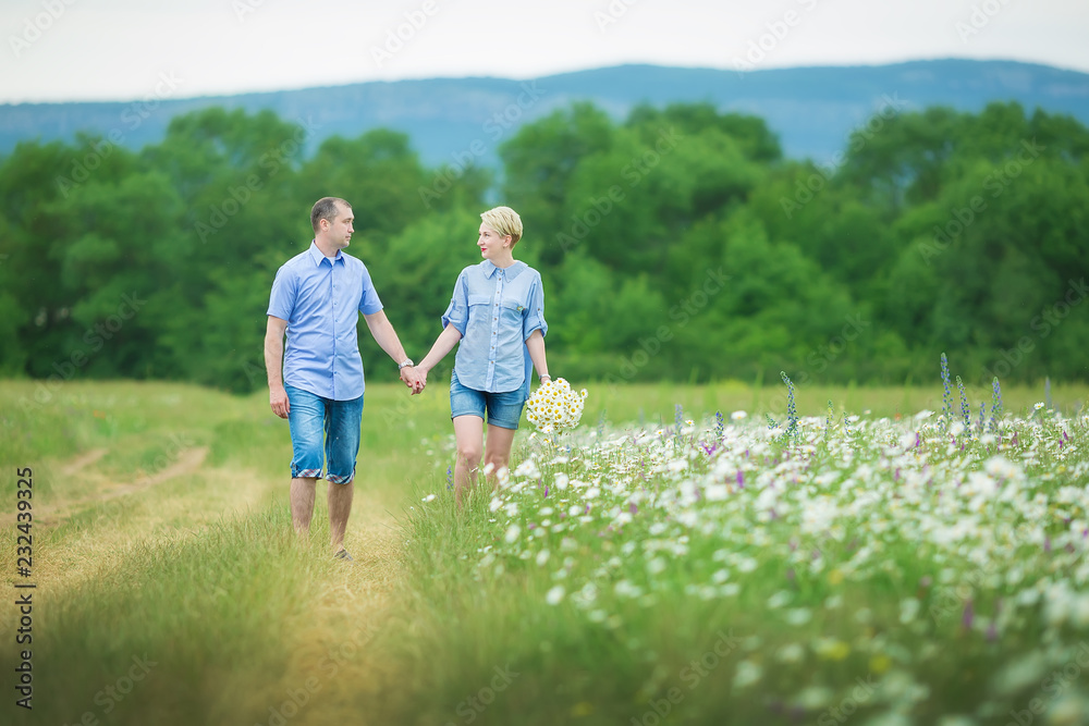 Romantic couple hugging and breathing fresh air in a warm field with daizy flowers Romantic couple hugging and breathing fresh air in a warm field with daizy flowers