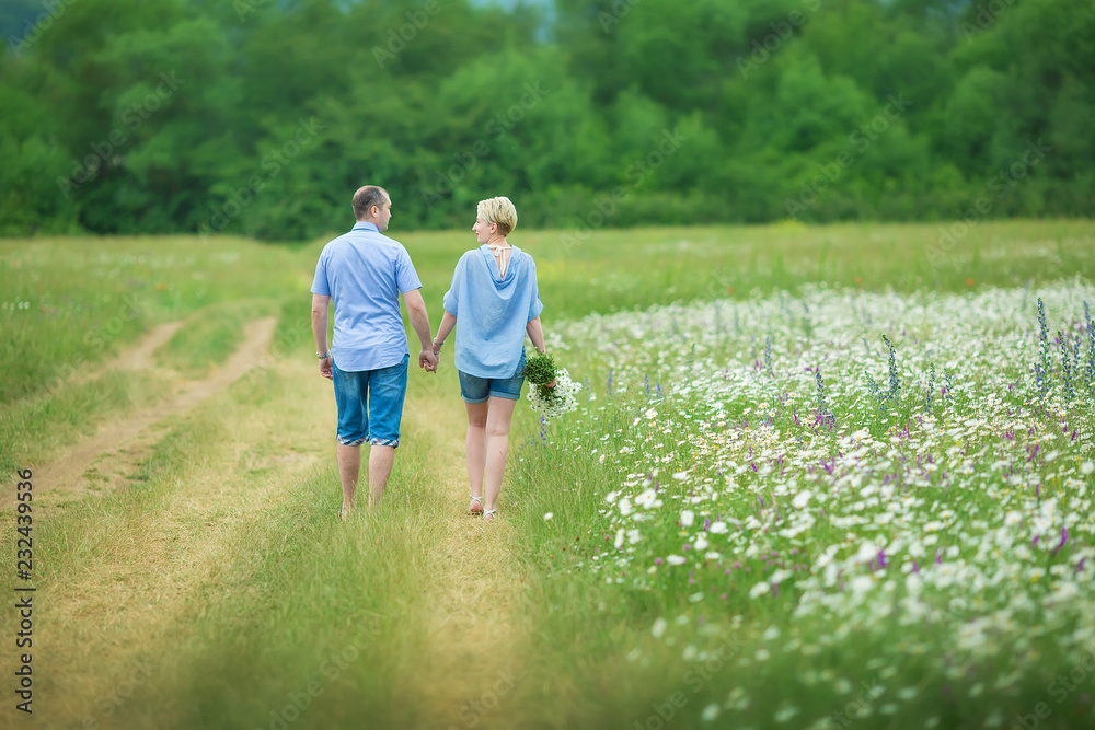 Romantic couple hugging and breathing fresh air in a warm field with daizy flowers Romantic couple hugging and breathing fresh air in a warm field with daizy flowers