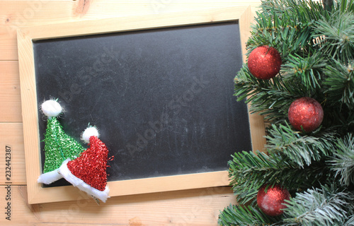 christmas tree with decorations ball on and blackboard on wooden background