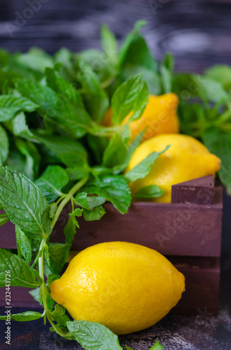 Healthy living concept.Fresh lemon and mint leaves in the wooden crate in the kitchen.