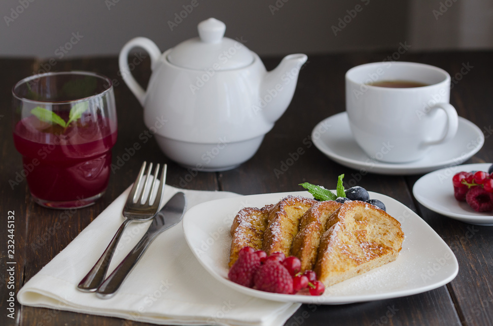 Spanish Torrijas or french toasts with berries and icing sugar for breakfast in hotel restaurant. Spanish Torrijas or french toasts with berries and icing sugar for breakfast in hotel restaurant.