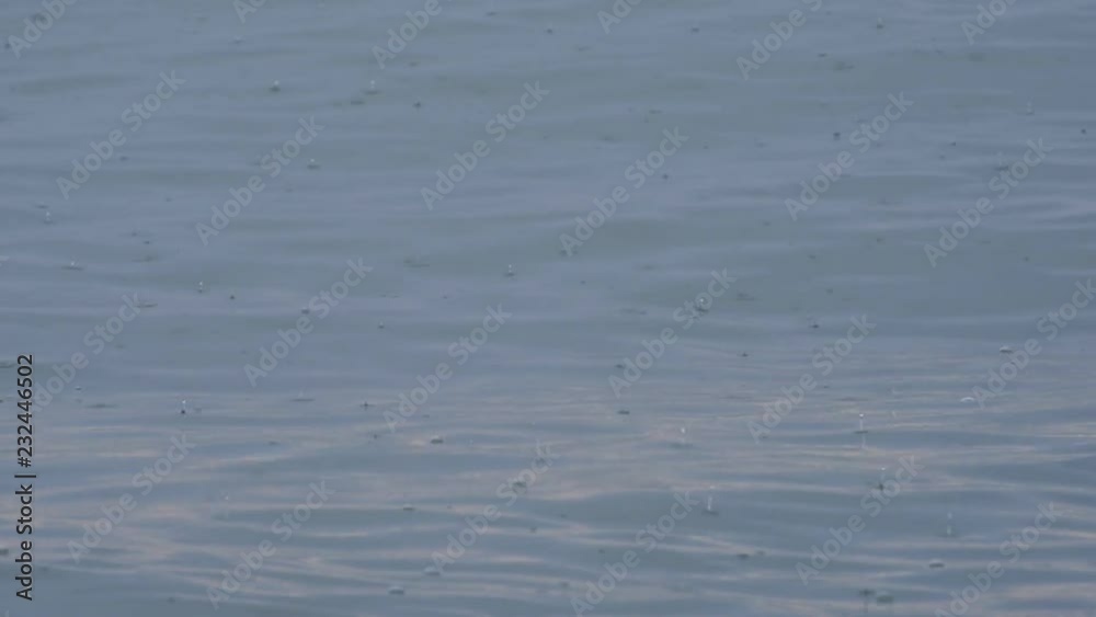 Rain falls onto sea waves, closeup. Rain drops on swaying water. Black Sea at Batumi main beach, Georgia, Europe Rain falls onto sea waves, closeup. Rain drops on swaying water. Black Sea at Batumi main beach, Georgia, Europe
