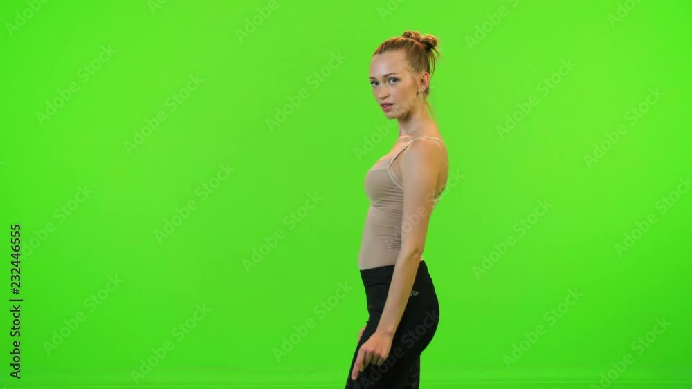 Beautiful sports model dancing happily over a green screen. Beautiful sports model dancing happily over a green screen.