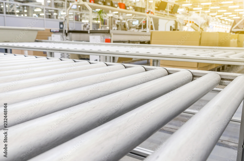 Table with metal rollers for transporting boxes in an industrial plant. Manufacturing enterprises Table with metal rollers for transporting boxes in an industrial plant. Manufacturing enterprises
