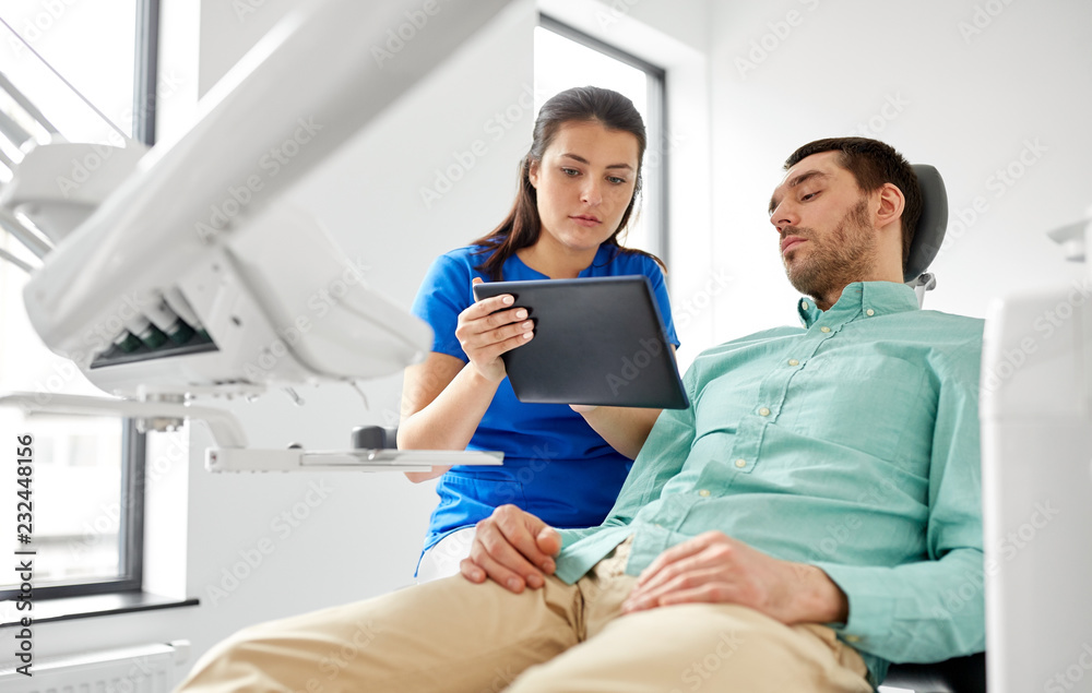 medicine, dentistry and healthcare concept - female dentist with tablet pc computer and male patient discussing teeth treatment at dental clinic office medicine, dentistry and healthcare concept - female dentist with tablet pc computer and male patient discussing teeth treatment at dental clinic office